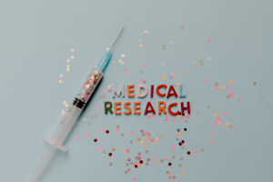 Syringe with confetti and the words Medical Research