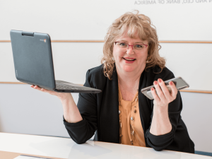 Nancy Ruffner holding a laptop and cell phone.